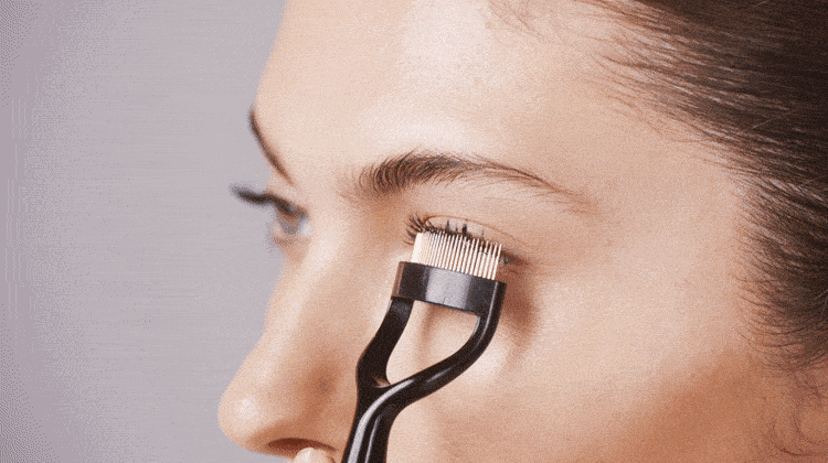 model using curl 60 lash comb to remove excess mascara from eyelashes